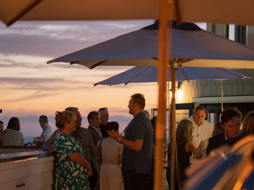 CRMBC members networking during the rooftop welcome reception at sunset, Newport Beach, August 2025 Annual Member Meeting.